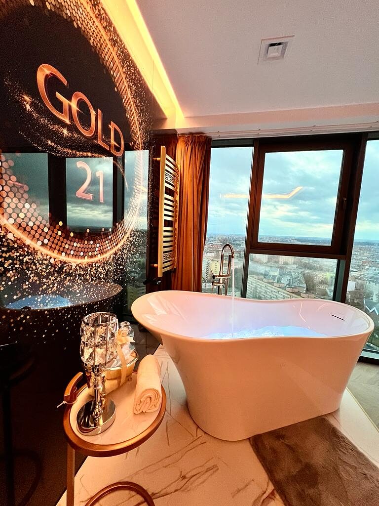 Wolnostojąca wanna z sygnaturą GOLD 21 na ścianie